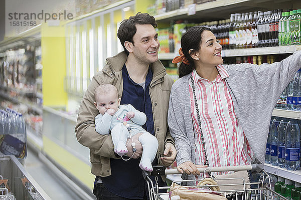 Ehepaar mit Baby beim Einkaufen im Supermarkt