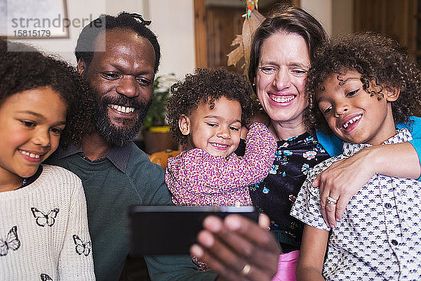 Glückliche multiethnische Familie macht Selfie mit Fotohandy