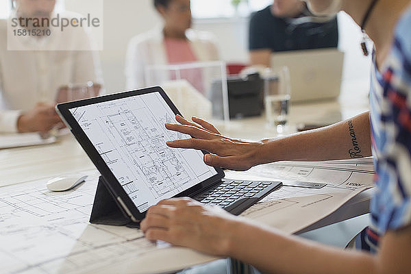 Eine Architektin betrachtet einen digitalen Bauplan auf einem digitalen Tablet mit Touchscreen