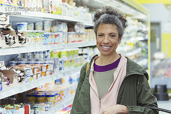 Porträt einer lächelnden  selbstbewussten Frau beim Einkaufen im Supermarkt