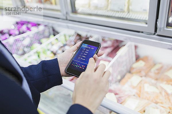 Frau mit Einkaufslisten-App  Einkaufen im Supermarkt