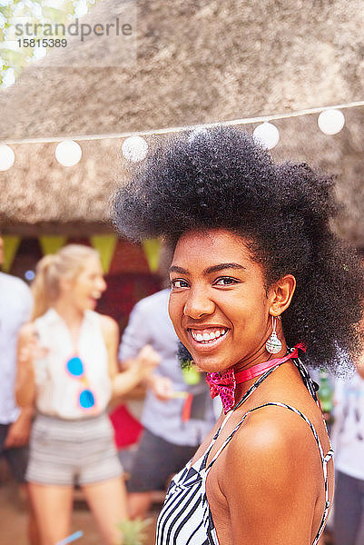 Porträt einer selbstbewussten  lächelnden jungen Frau auf einem Sommerfest