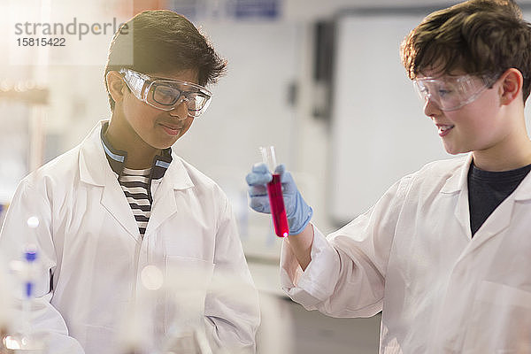 Junge Studenten  die eine Flüssigkeit im Reagenzglas untersuchen und ein wissenschaftliches Experiment im Labor durchführen