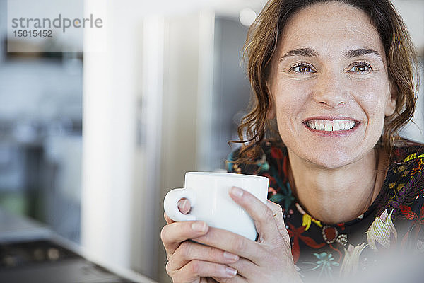 Porträt lächelnde brünette Frau trinkt Kaffee