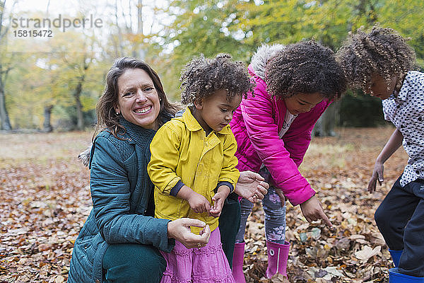 Porträt glückliche Mutter und Kinder spielen im Herbst Blätter