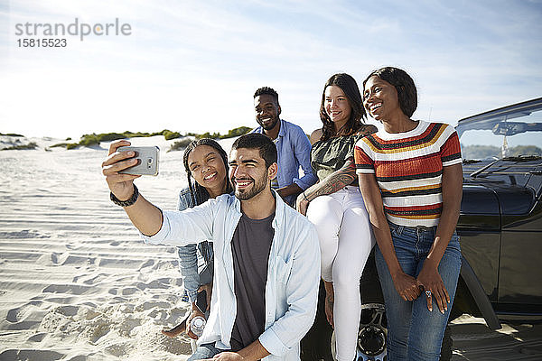 Junge Freunde mit Fotohandy machen ein Selfie am Strand