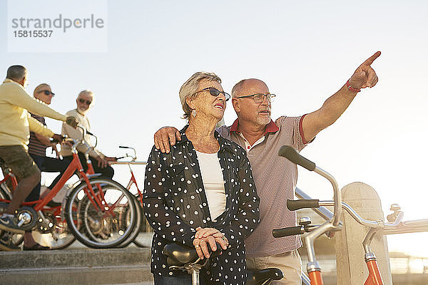 Aktives älteres Touristenpaar mit Fahrrädern und Blick auf die Landschaft