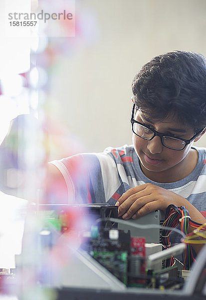 Fokussierter Junge  der einen Computer im Klassenzimmer zusammenbaut