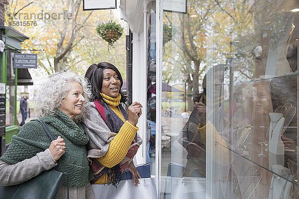 Ältere Frauen beim Schaufensterbummel vor einem städtischen Geschäft