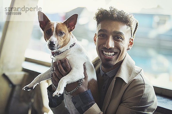 Porträt lächelnder junger Mann mit Hund