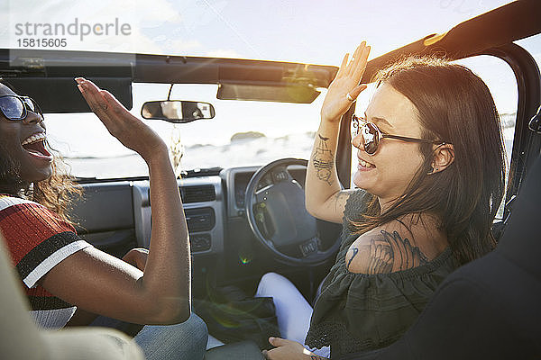 Junge Frauen Freunde High-fiving in sonnigen Jeep  genießen Road Trip