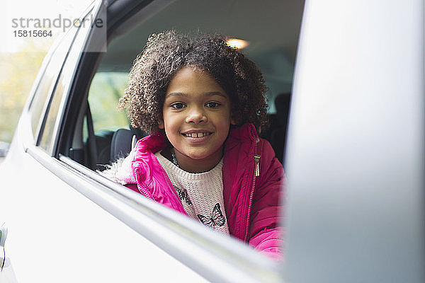 Porträt glückliches Mädchen auf dem Rücksitz eines Autos