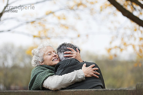 Zärtliches  zartes älteres Paar  das sich im Herbst im Park umarmt