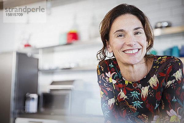 Porträt selbstbewusste lächelnde brünette Frau in der Küche