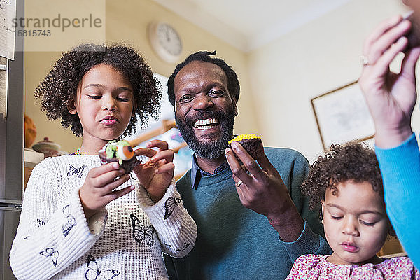Porträt glücklicher Vater und Töchter  die Muffins essen
