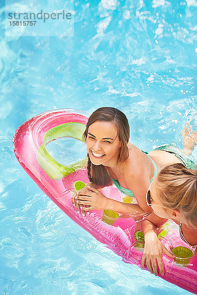 Portrait lächelnd Frauen Freunde schwimmend auf Pool Floß im Sommer Schwimmbad