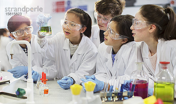 Neugierige Schüler führen ein wissenschaftliches Experiment durch und untersuchen eine Flüssigkeit in einem Becherglas in einem Laborklassenzimmer