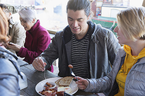 Ein Paar frühstückt gemeinsam auf der Terrasse eines Restaurants