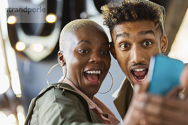 Verspieltes junges Paar macht Selfie mit Fotohandy