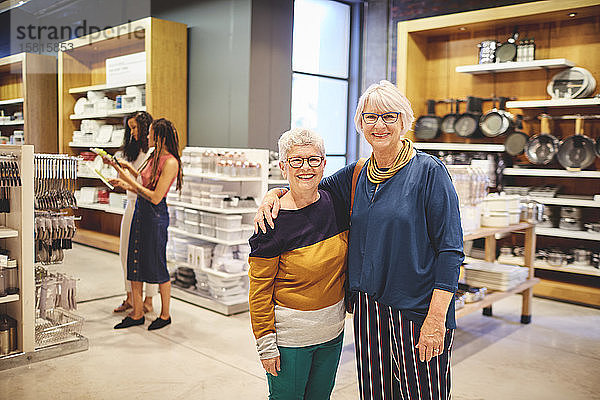 Porträt glücklicher älterer Frauen  die in einem Haushaltswarengeschäft einkaufen