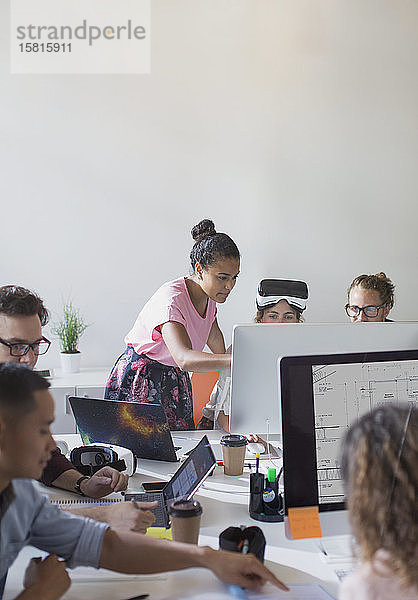 Computerprogrammierer und Designer arbeiten an Computern in einem Großraumbüro