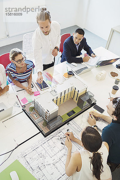 Männlicher Architekt  der eine Besprechung im Konferenzraum leitet und ein Modell erklärt