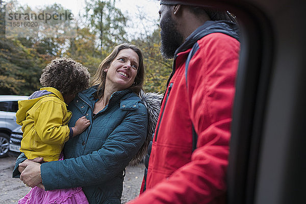 Multiethnische Familie im Gespräch auf dem Parkplatz