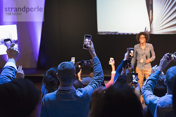 Zuhörer mit Smartphones  die den Redner auf der Bühne der Konferenz filmen
