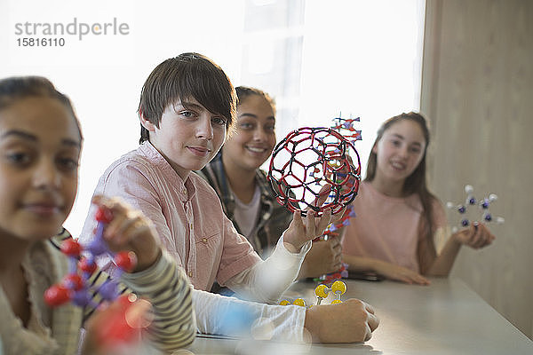Porträt selbstbewusster Studenten  die molekulare Strukturen im Laborunterricht halten