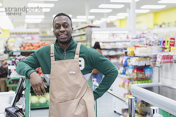 Porträt selbstbewusster männlicher Lebensmittelhändler bei der Arbeit im Supermarkt