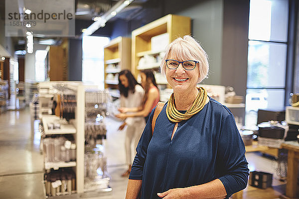Porträt einer lächelnden  selbstbewussten älteren Frau beim Einkaufen in einem Haushaltswarengeschäft