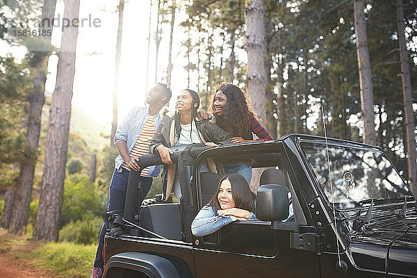 Junge Freunde im Jeep  die die Bäume im Wald betrachten und die Fahrt genießen