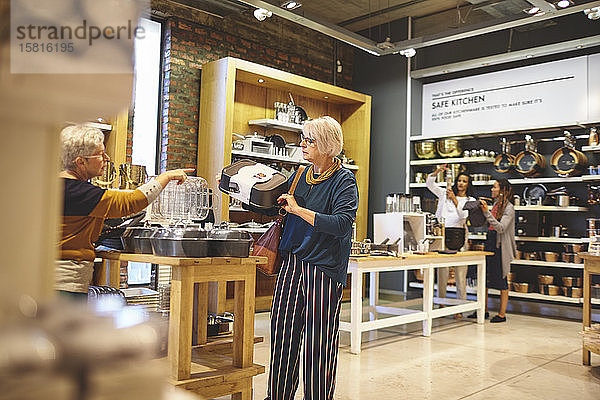 Ältere Frauen beim Einkaufen von Backformen in einem Haushaltswarengeschäft