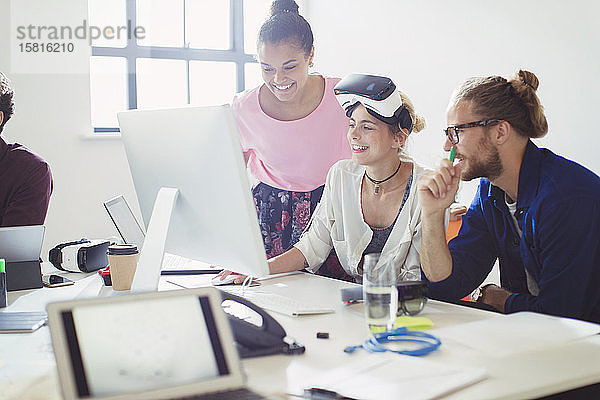 Computerprogrammierer beim Programmieren einer Virtual-Reality-Simulator-Brille am Computer im Büro