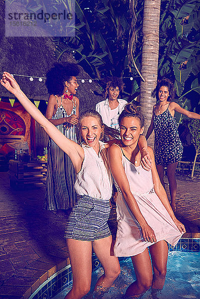 Porträt ausgelassene junge Frauen Freunde feiern  tanzen und waten bei Pool-Party