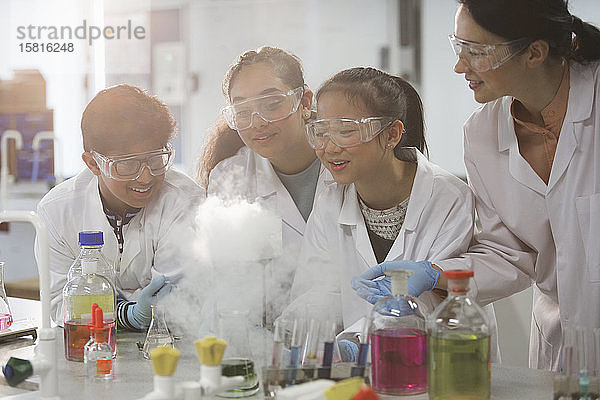 Lehrerin und Schüler beobachten wissenschaftliches Experiment chemische Reaktion im Labor Klassenzimmer