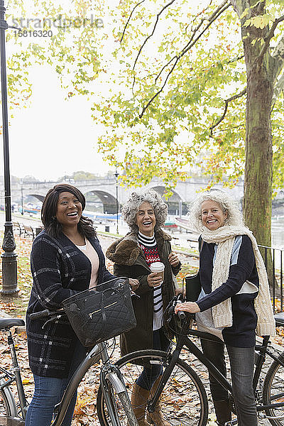 Porträt lächelnd  zuversichtlich  aktive ältere Frauen Freunde mit Kaffee und Fahrräder im Herbst Park