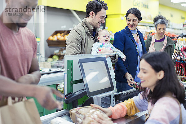 Kassiererin hilft Kunden an der Supermarktkasse