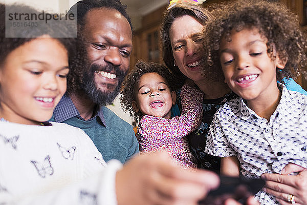 Glückliche multiethnische Familie mit Smartphone