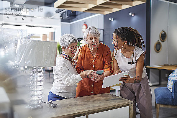 Frau hilft Kunden beim Einkaufen in einem Geschäft für Wohnkultur