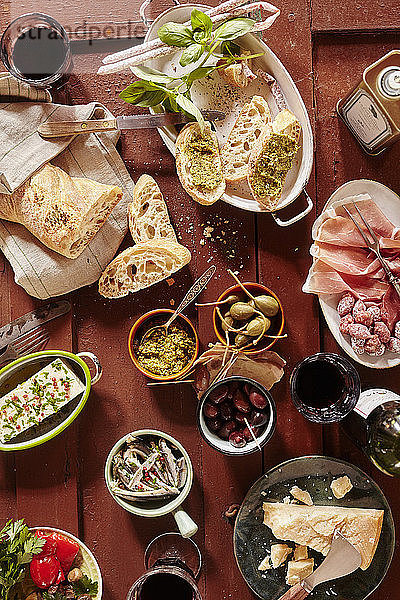 Bruschetta mit Pesto  Mini-Salami  Oliven  Parmesan  Olivenöl  Riesenkapern und Rotwein