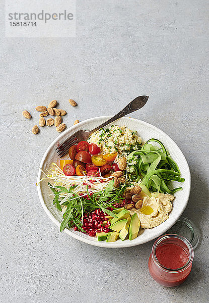 Eine Salatschüssel mit Couscous  Gemüse und einem fruchtigen Dressing