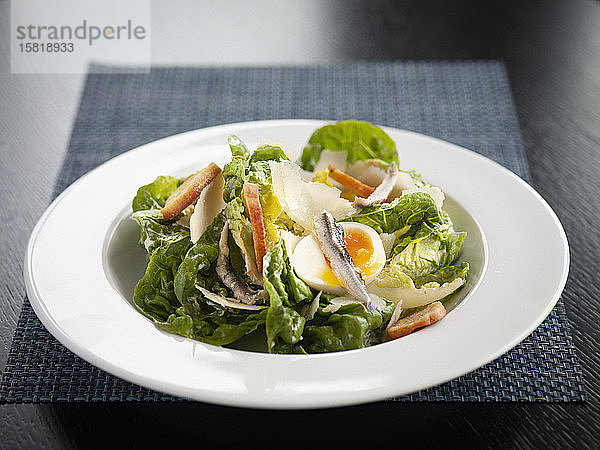 Caesar Salad mit Sardellen  gekochtem Ei  Brotchips und Parmesan