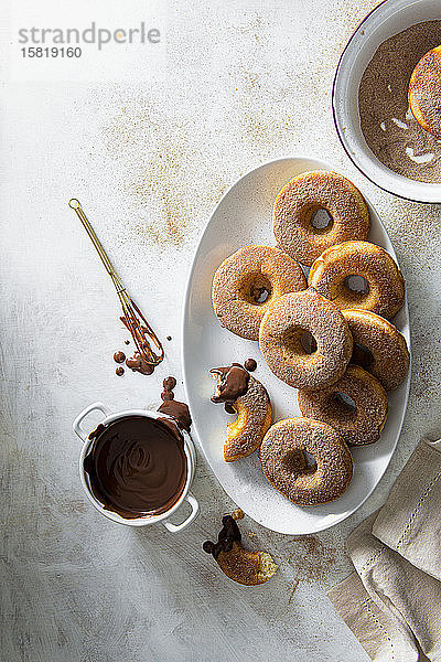 Gebackene Donuts mit Zimtzucker überzogen und mit Schokoladensauce zum Dippen serviert