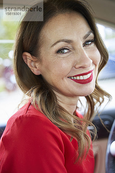 Porträt einer lächelnden reifen Frau im Auto