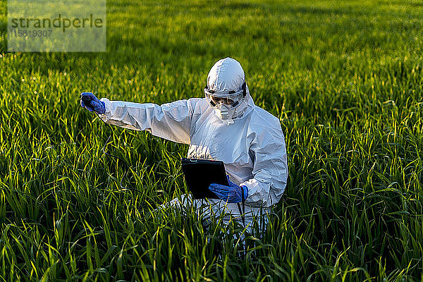 Wissenschaftlerin  die im Feld forscht und Messgeräte benutzt