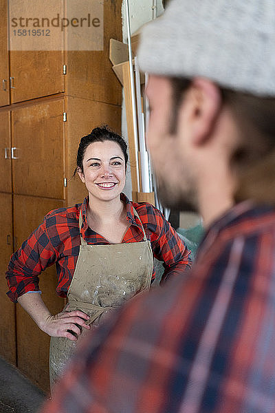 Handwerkerinnen und Handwerker im Gespräch in ihrer Werkstatt