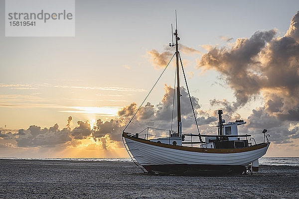 Dänemark  Slettestrand  Fischerboot bei Sonnenuntergang am sandigen Küstenstrand