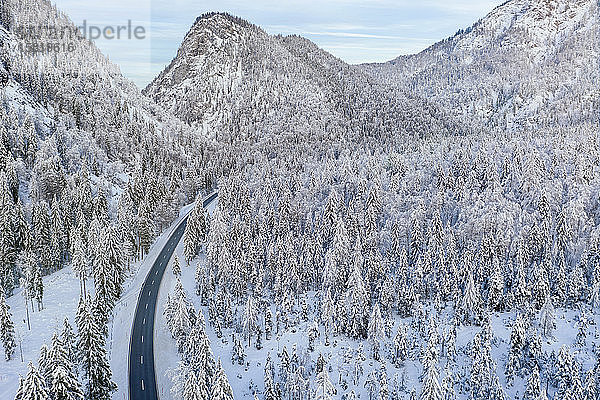 Deutschland  Bayern  Luftaufnahme von Bergautobahn und schneebedecktem Wald im Winter