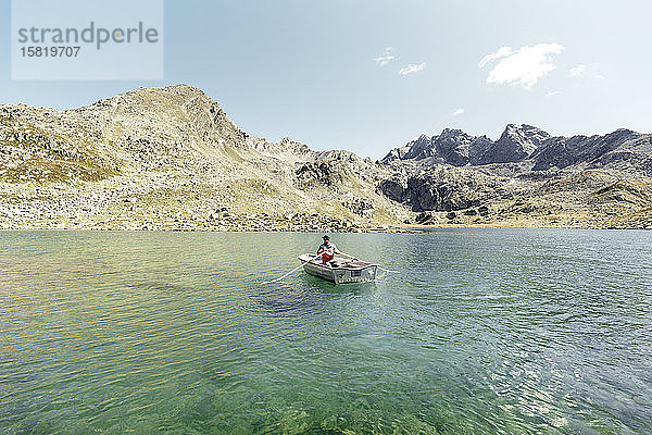 Mann in einem Ruderboot auf dem kristallklaren Bergsee Suretta  Graubünden  Schweiz